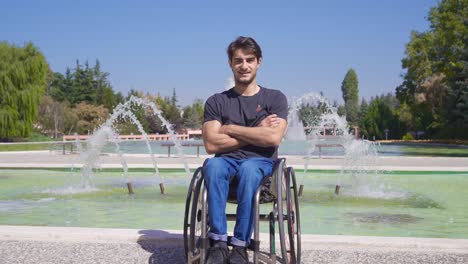 Behinderter-Junger-Mann-Im-Rollstuhl,-Der-In-Die-Kamera-Blickt-Und-Lächelt.